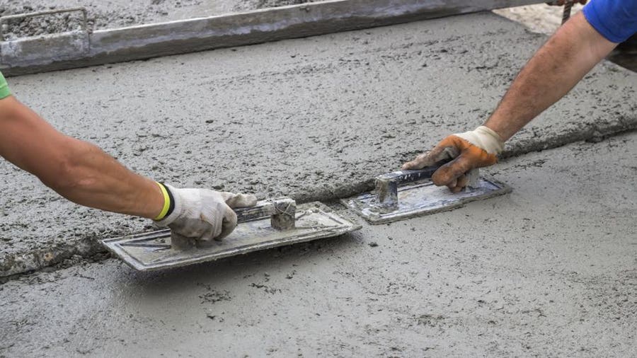 Concrete finisher hand-troweling a fresh pour